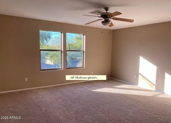 en empty room with windows and ceiling fan