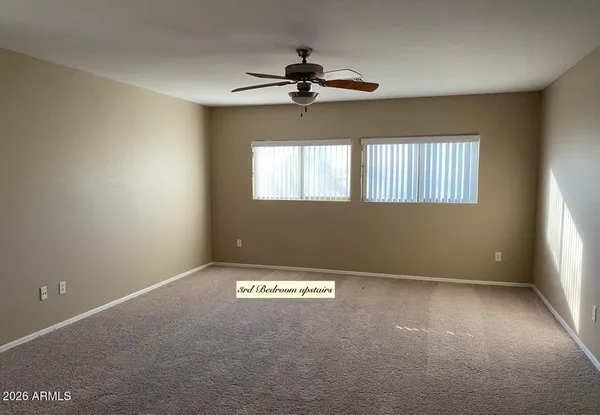 a view of a livingroom with a ceiling fan and window