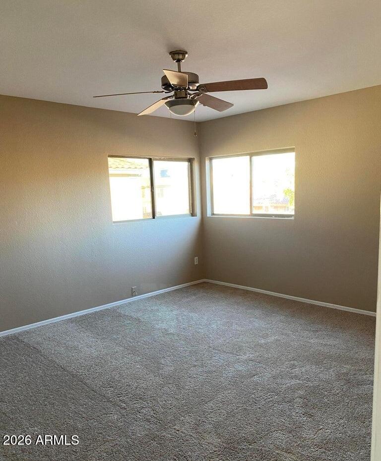 3427 East Derringer Way Gilbert, AZ 85297 - Photo 16 of 23 an empty room with windows and chandelier fan