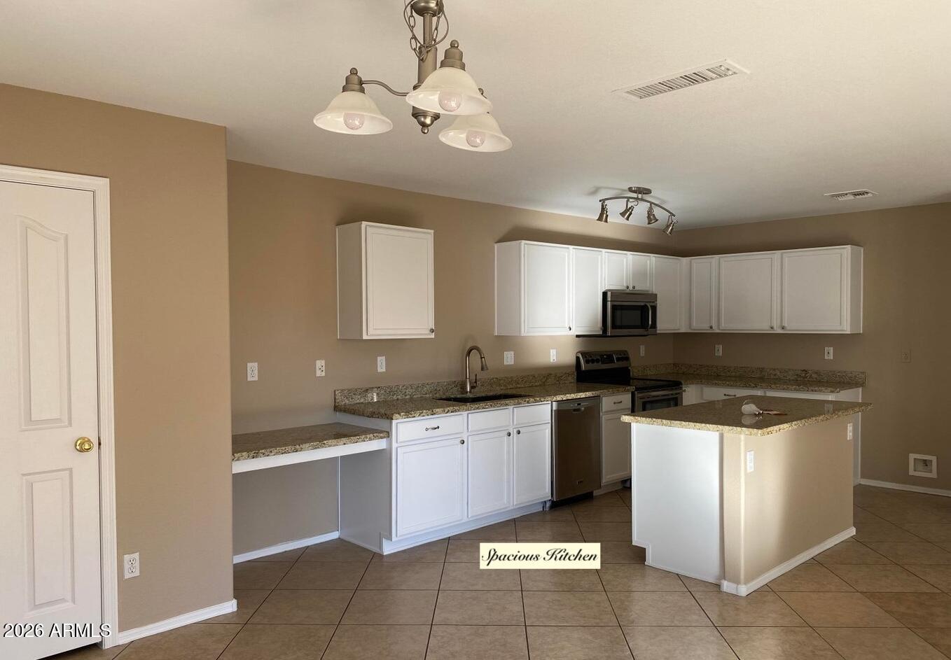 3427 East Derringer Way Gilbert, AZ 85297 - Photo 5 of 23 a kitchen with stainless steel appliances granite countertop a sink and stove top oven