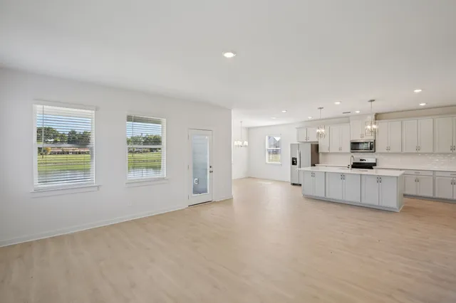 a view of kitchen with kitchen island white cabinets and wooden floor