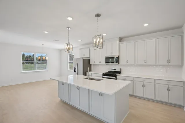 a kitchen that has a lot of cabinets and wooden floor