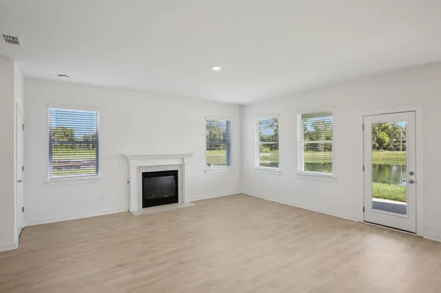 an empty room with windows and fireplace