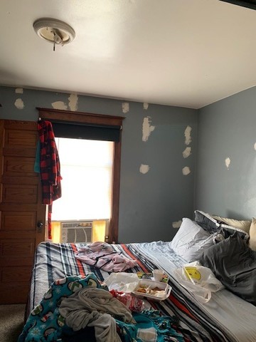 5929 West Rice Street Chicago, IL 60651 - Photo 15 of 29 a bed sitting in a bedroom next to a window