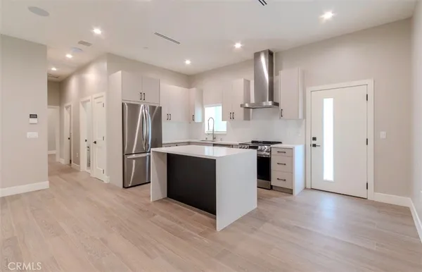 a kitchen with stainless steel appliances kitchen island granite countertop a refrigerator and a stove top oven