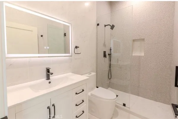 a bathroom with a sink a toilet and shower