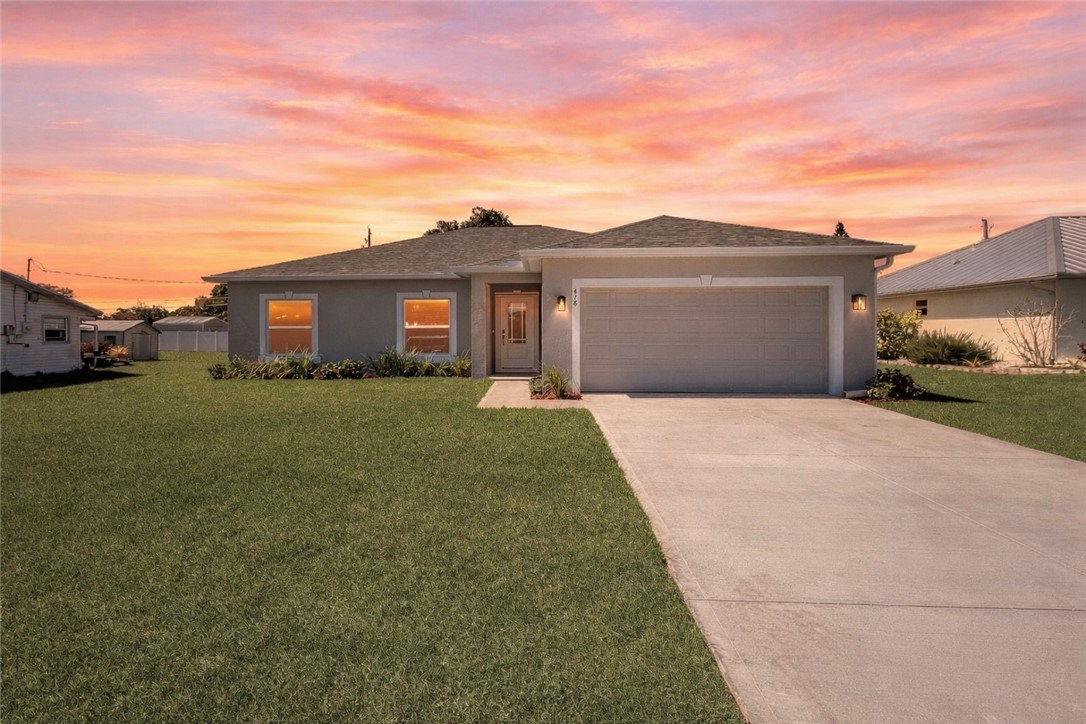 418 Easy Street Sebastian, FL 32958 - Photo 1 of 34 a front view of a house with a yard and garage