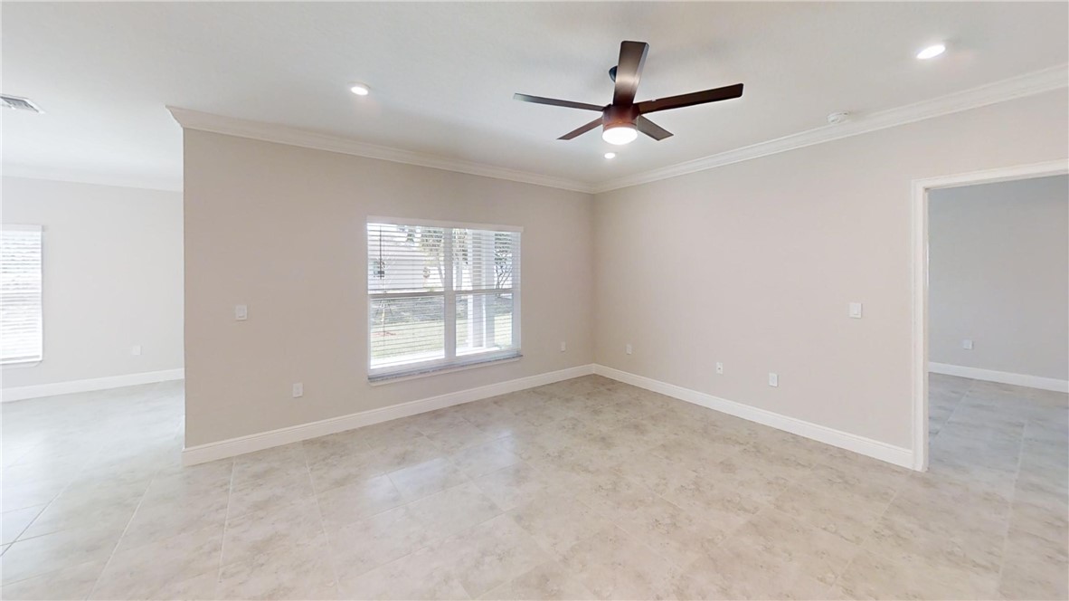 418 Easy Street Sebastian, FL 32958 - Photo 13 of 34 an empty room with ceiling fan and windows