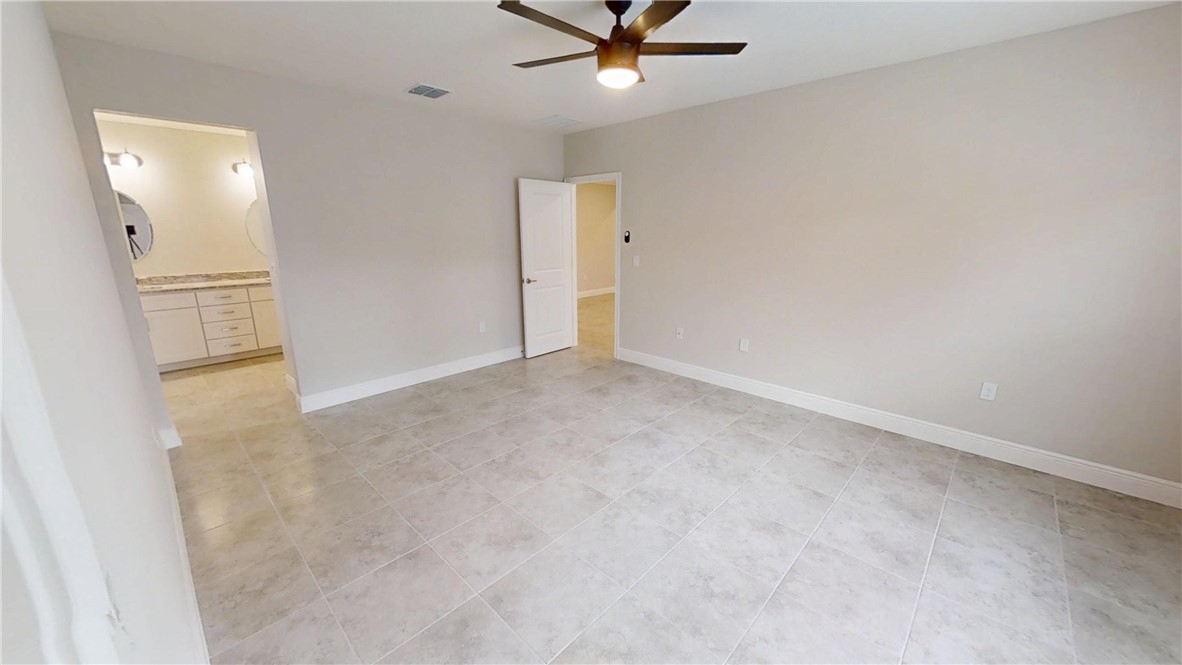 418 Easy Street Sebastian, FL 32958 - Photo 16 of 34 an empty room with a ceiling fan and carpet