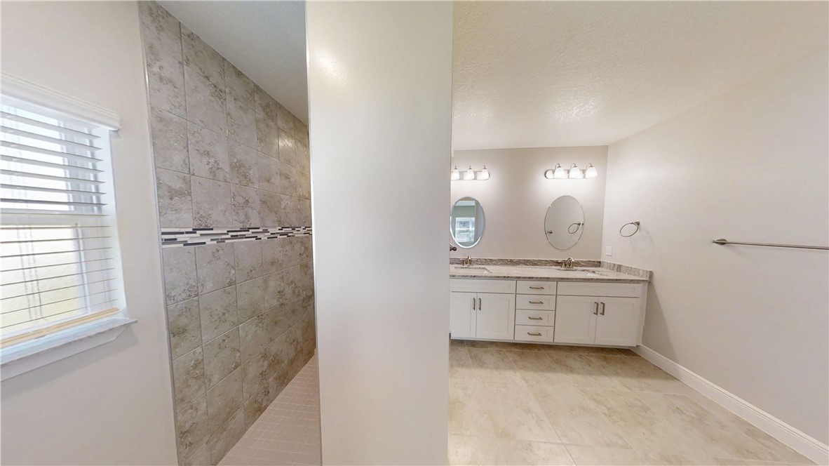 418 Easy Street Sebastian, FL 32958 - Photo 18 of 34 a bathroom with a granite countertop sink a toilet and a mirror
