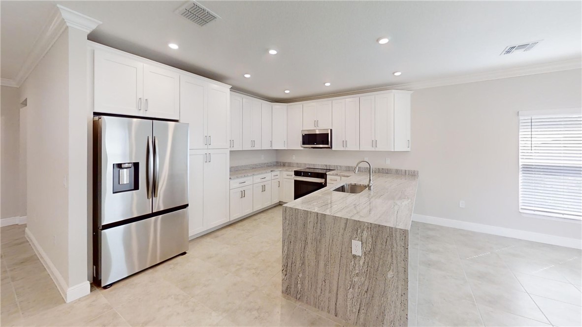 418 Easy Street Sebastian, FL 32958 - Photo 3 of 34 a kitchen with stainless steel appliances granite countertop a refrigerator sink and microwave