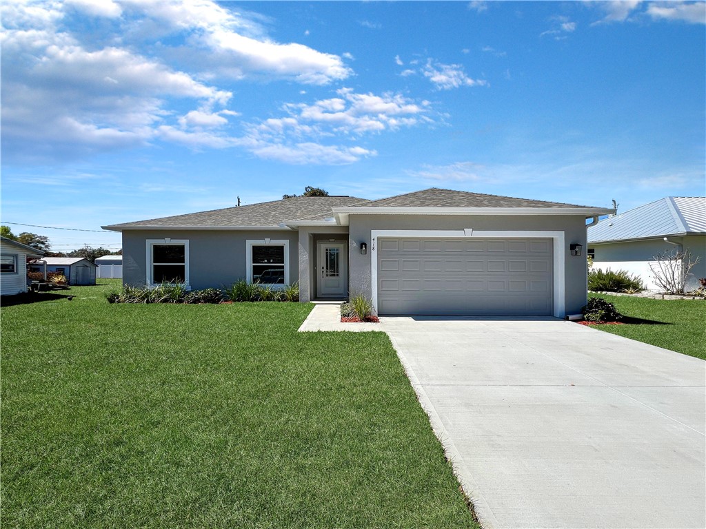 418 Easy Street Sebastian, FL 32958 - Photo 31 of 34 a front view of a house with a yard and garage
