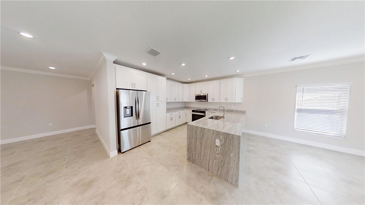 418 Easy Street Sebastian, FL 32958 - Photo 7 of 34 a living room with stainless steel appliances kitchen island granite countertop a sink and cabinets