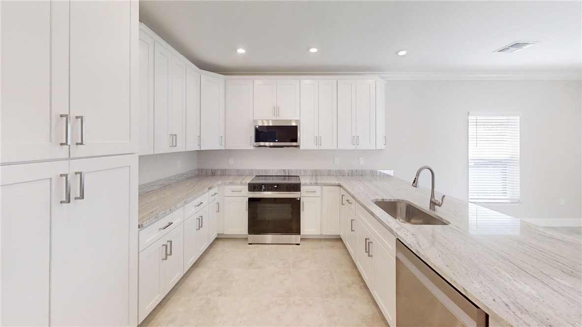 418 Easy Street Sebastian, FL 32958 - Photo 9 of 34 a kitchen with granite countertop white cabinets and stainless steel appliances