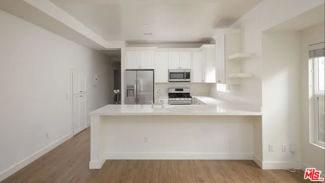 a kitchen with kitchen island a sink appliances and cabinets