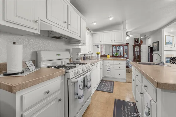 a kitchen with granite countertop a sink stove and cabinets