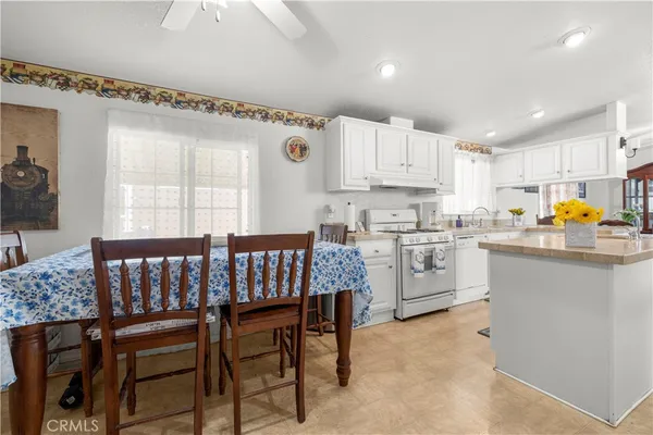 a kitchen with a table chairs sink microwave and cabinets