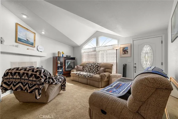 a living room with furniture a fireplace and large windows