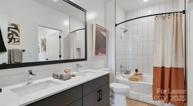 a bathroom with a sink vanity granite toilet and shower