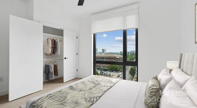 a bedroom with a bed and a large mirror next to a window