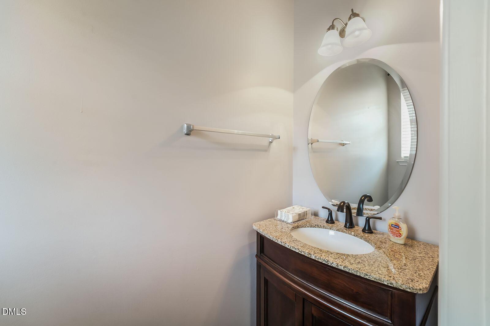 4909 Blue Rock Court Raleigh, NC 27610 - Photo 7 of 15 a bathroom with a granite countertop sink and a mirror