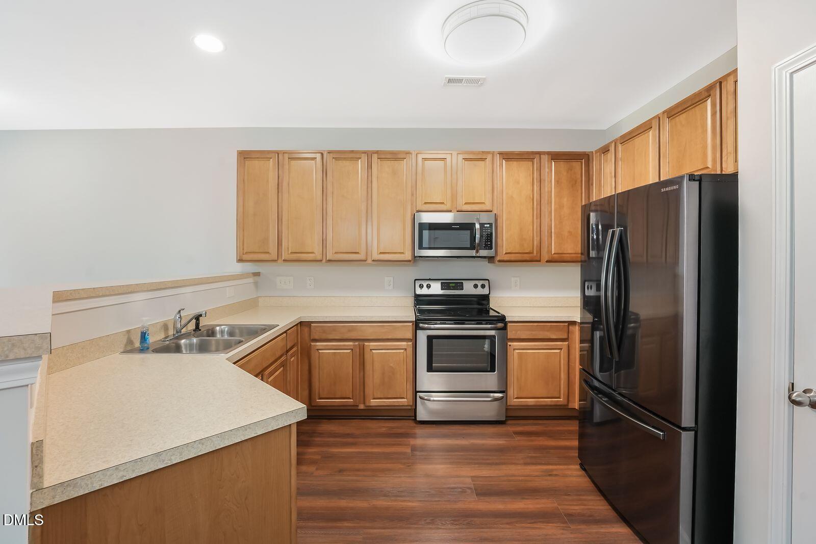 4909 Blue Rock Court Raleigh, NC 27610 - Photo 8 of 15 a kitchen with a sink stainless steel appliances and cabinets