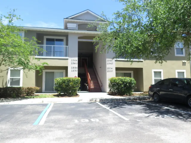 a view of a car parked in front of a brick house