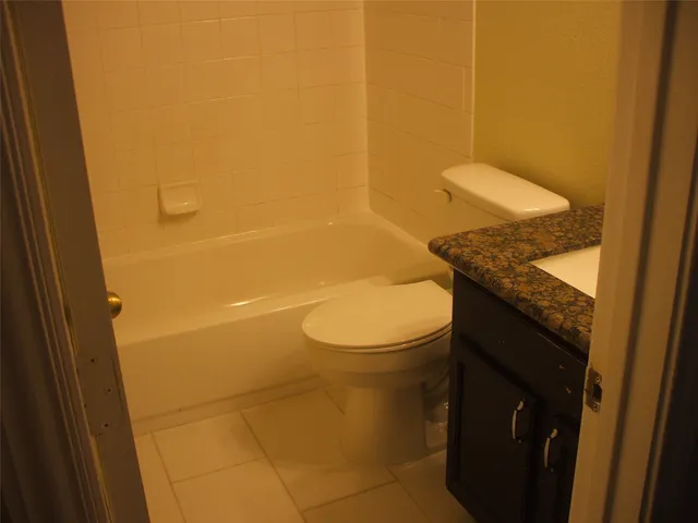 a bathroom with a granite countertop toilet and sink