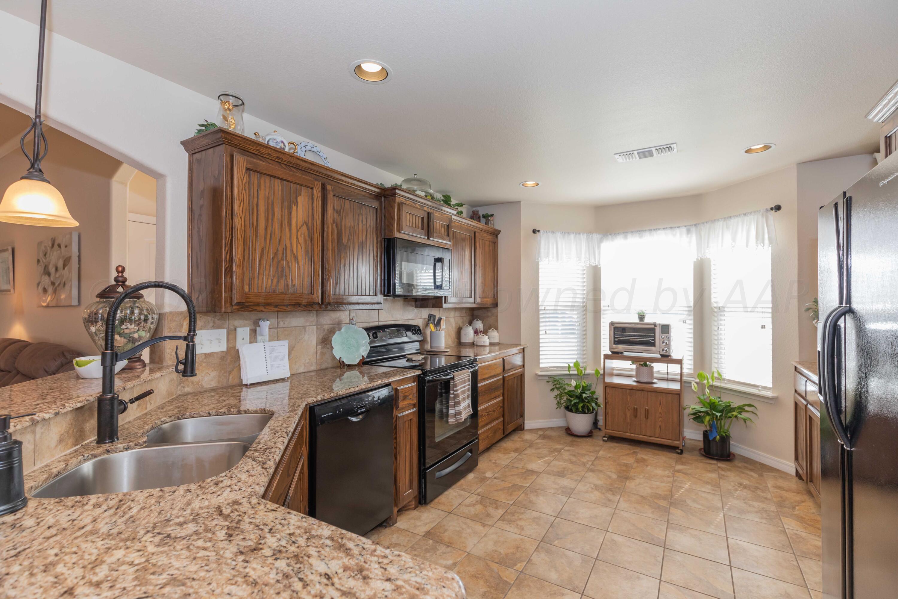 5904 South Rusk Street Amarillo, TX 79118 - Photo 11 of 49 a kitchen with stainless steel appliances granite countertop a sink stove and refrigerator