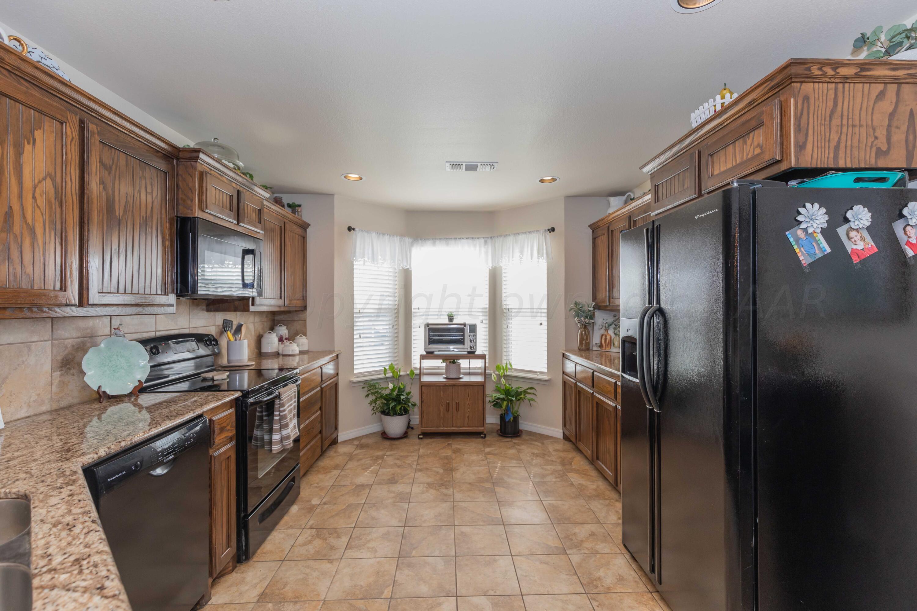 5904 South Rusk Street Amarillo, TX 79118 - Photo 12 of 49 a kitchen with stainless steel appliances granite countertop a refrigerator a stove top oven a sink and dishwasher