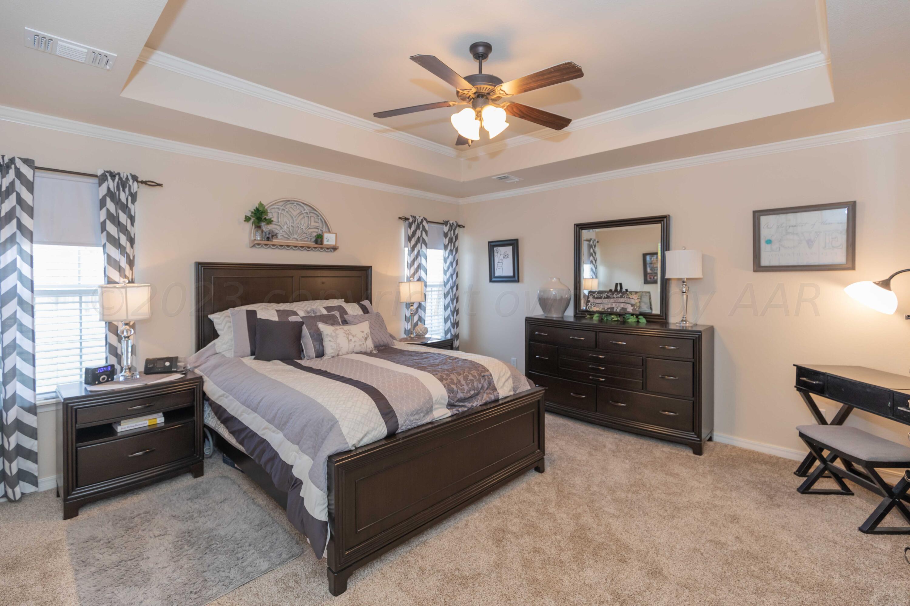 5904 South Rusk Street Amarillo, TX 79118 - Photo 20 of 49 a bedroom with a bed and a chandelier