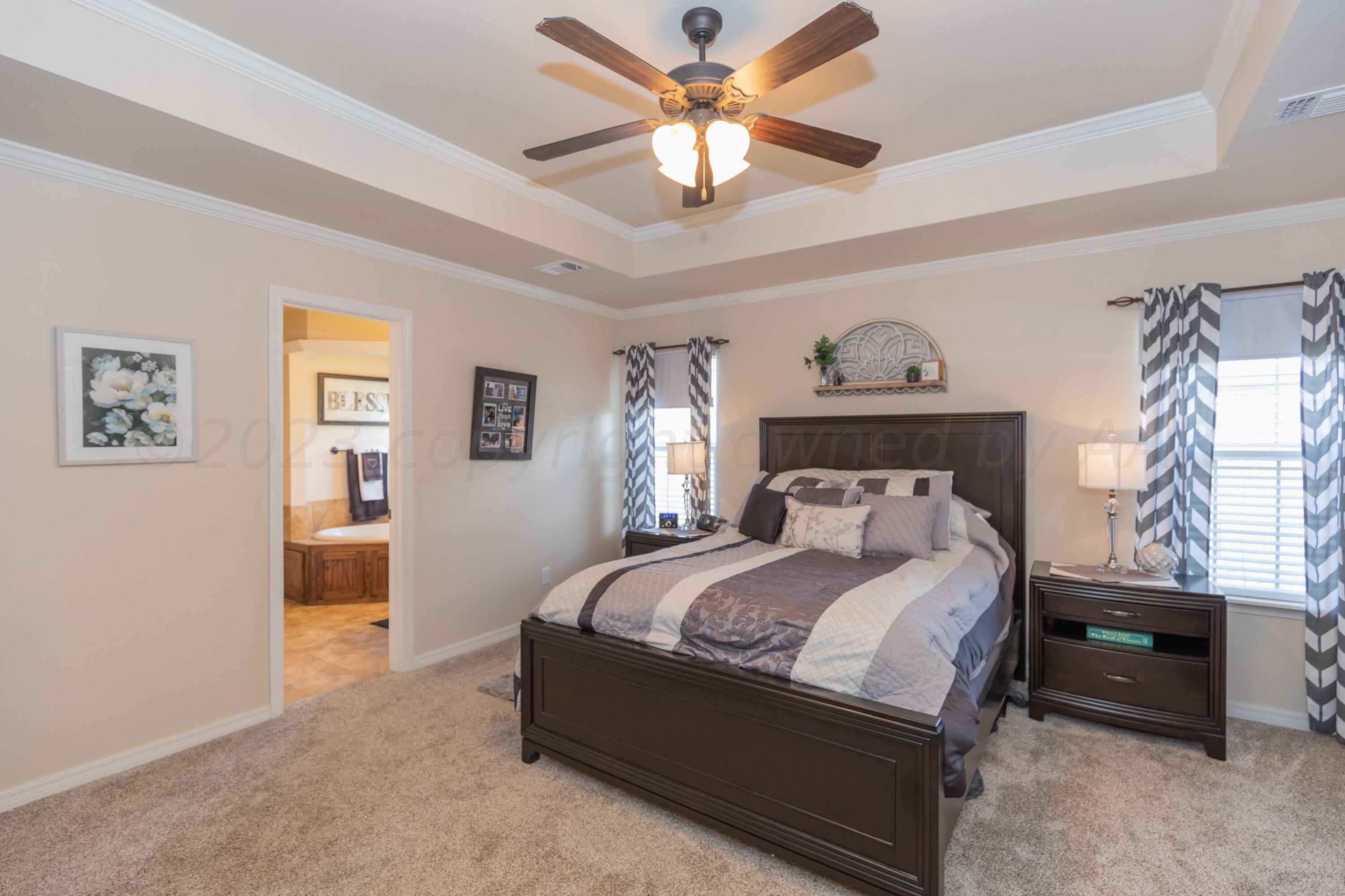 5904 South Rusk Street Amarillo, TX 79118 - Photo 21 of 49 a bedroom with a bed and a chandelier