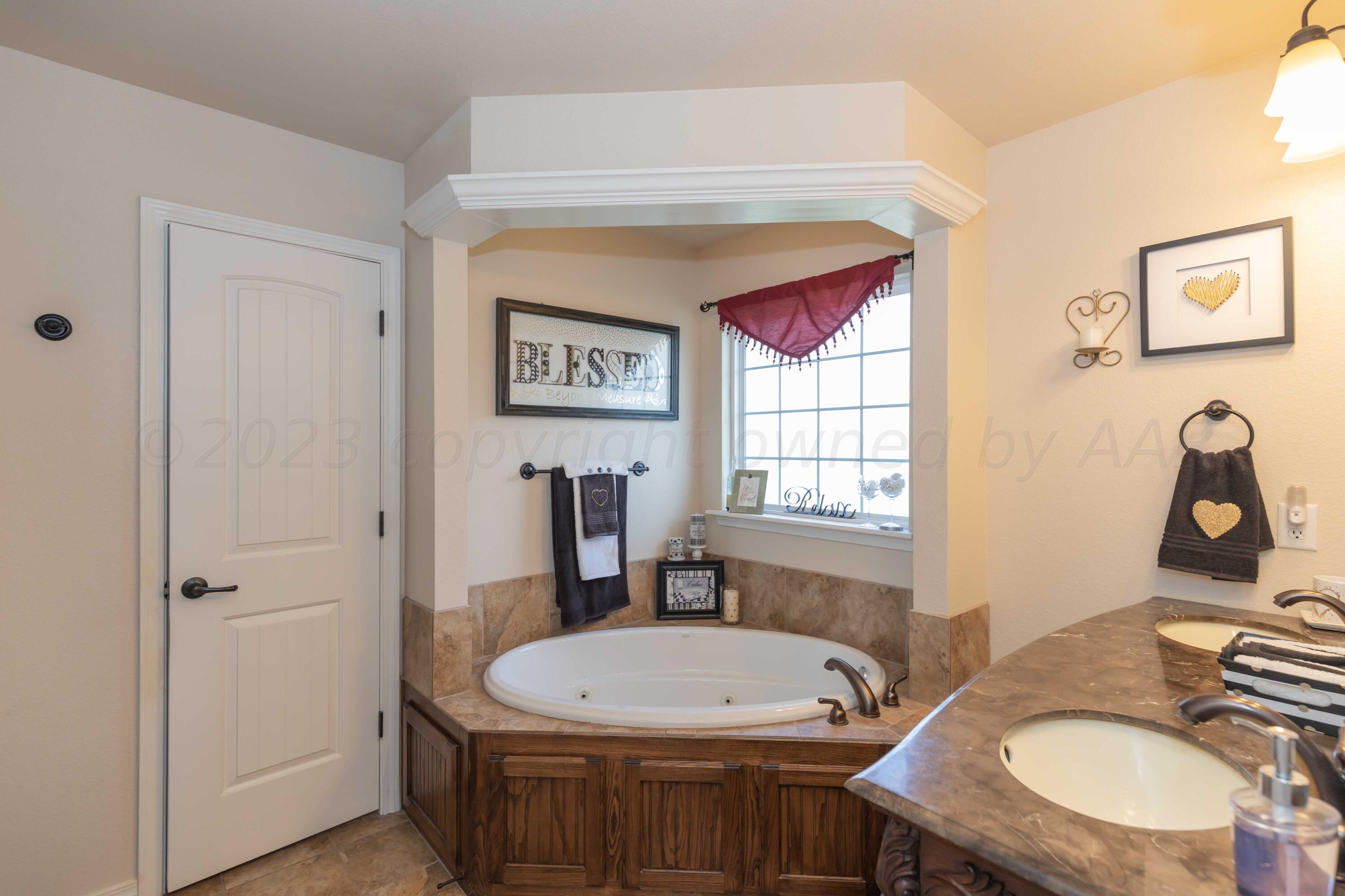 5904 South Rusk Street Amarillo, TX 79118 - Photo 24 of 49 a bathroom with a granite countertop sink a toilet and a window
