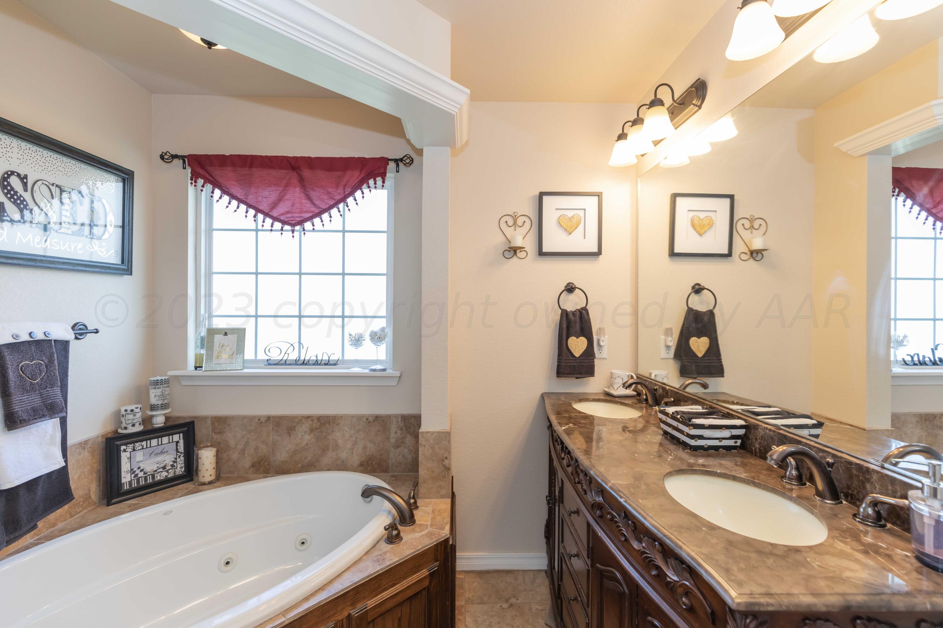 5904 South Rusk Street Amarillo, TX 79118 - Photo 28 of 49 a bathroom with a tub sink and mirror