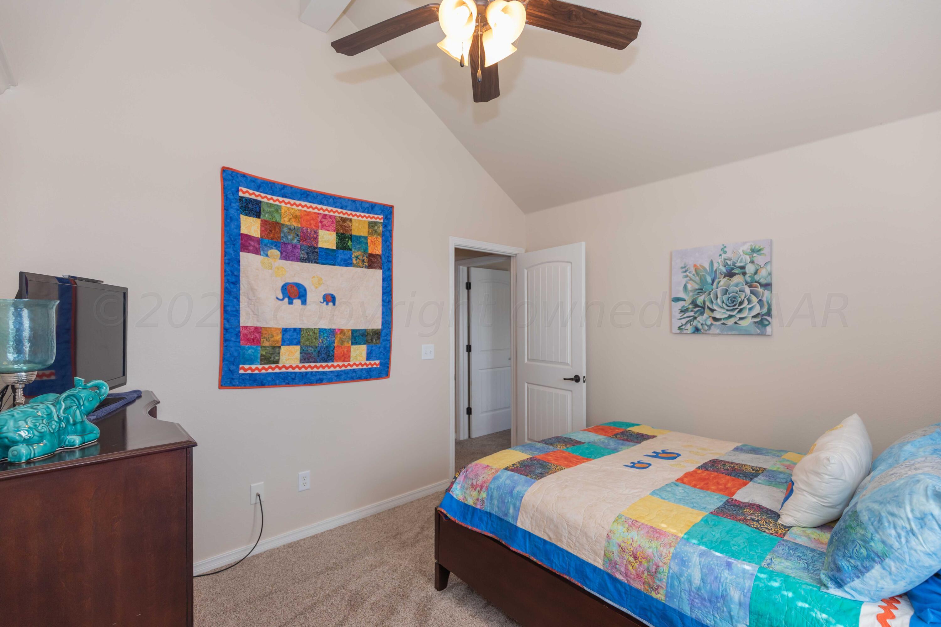 5904 South Rusk Street Amarillo, TX 79118 - Photo 31 of 49 a bedroom with a bed and a chandelier