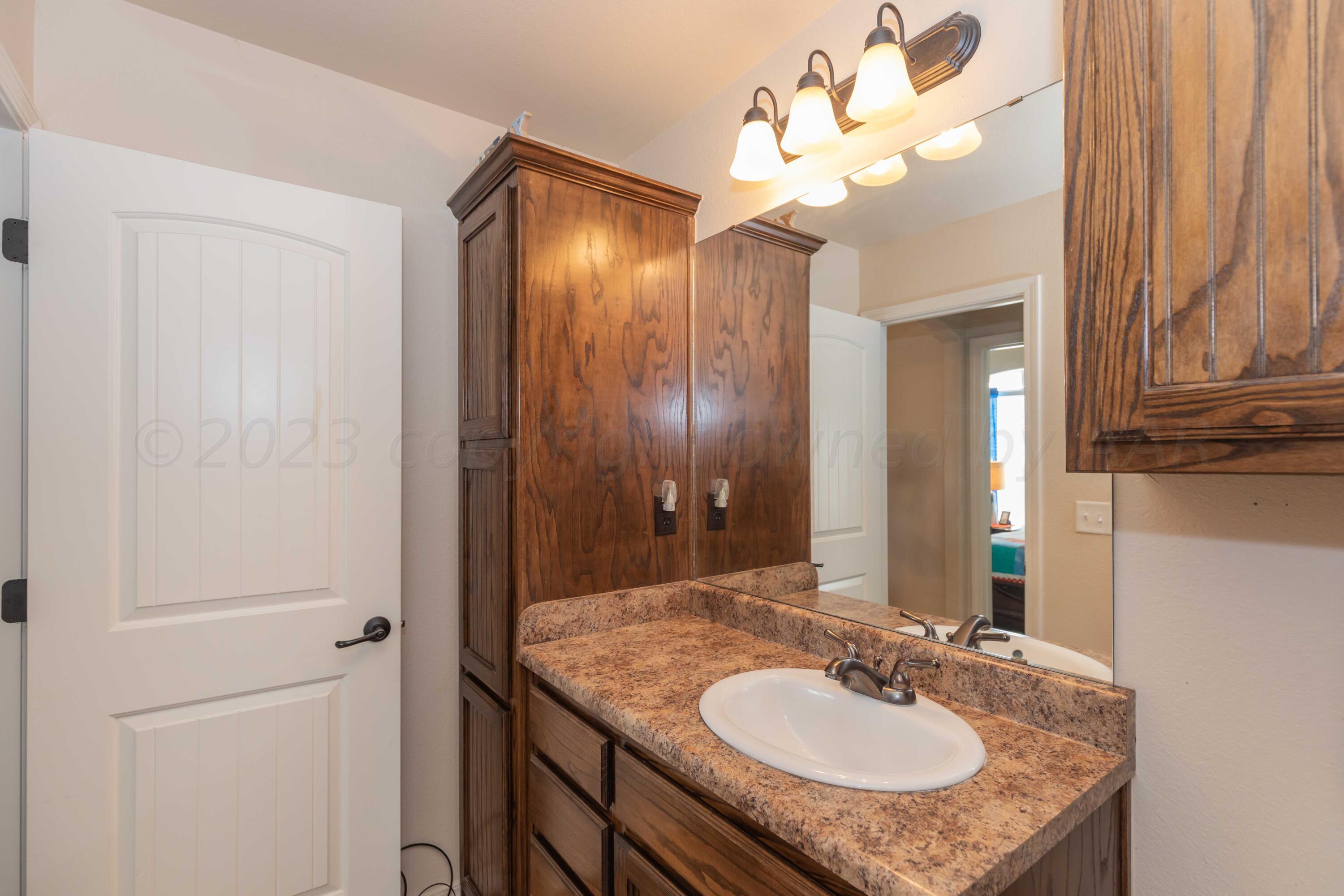 5904 South Rusk Street Amarillo, TX 79118 - Photo 34 of 49 a bathroom with a granite countertop sink and a mirror