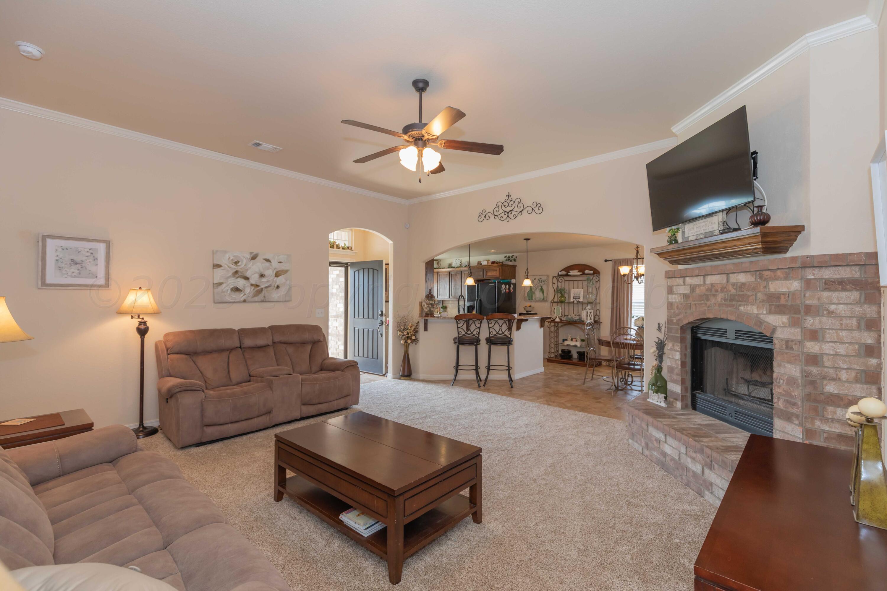 5904 South Rusk Street Amarillo, TX 79118 - Photo 10 of 49 a living room with furniture a flat screen tv and a fireplace