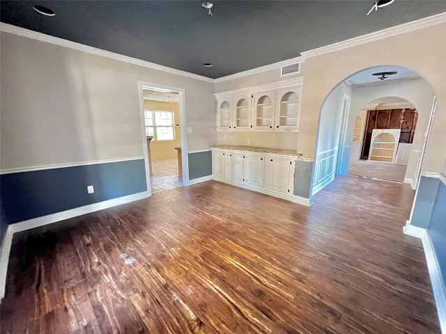 a view of a hallway with wooden floor and dining room