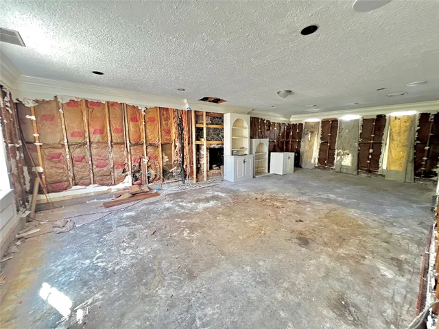 an empty room with large windows and furniture