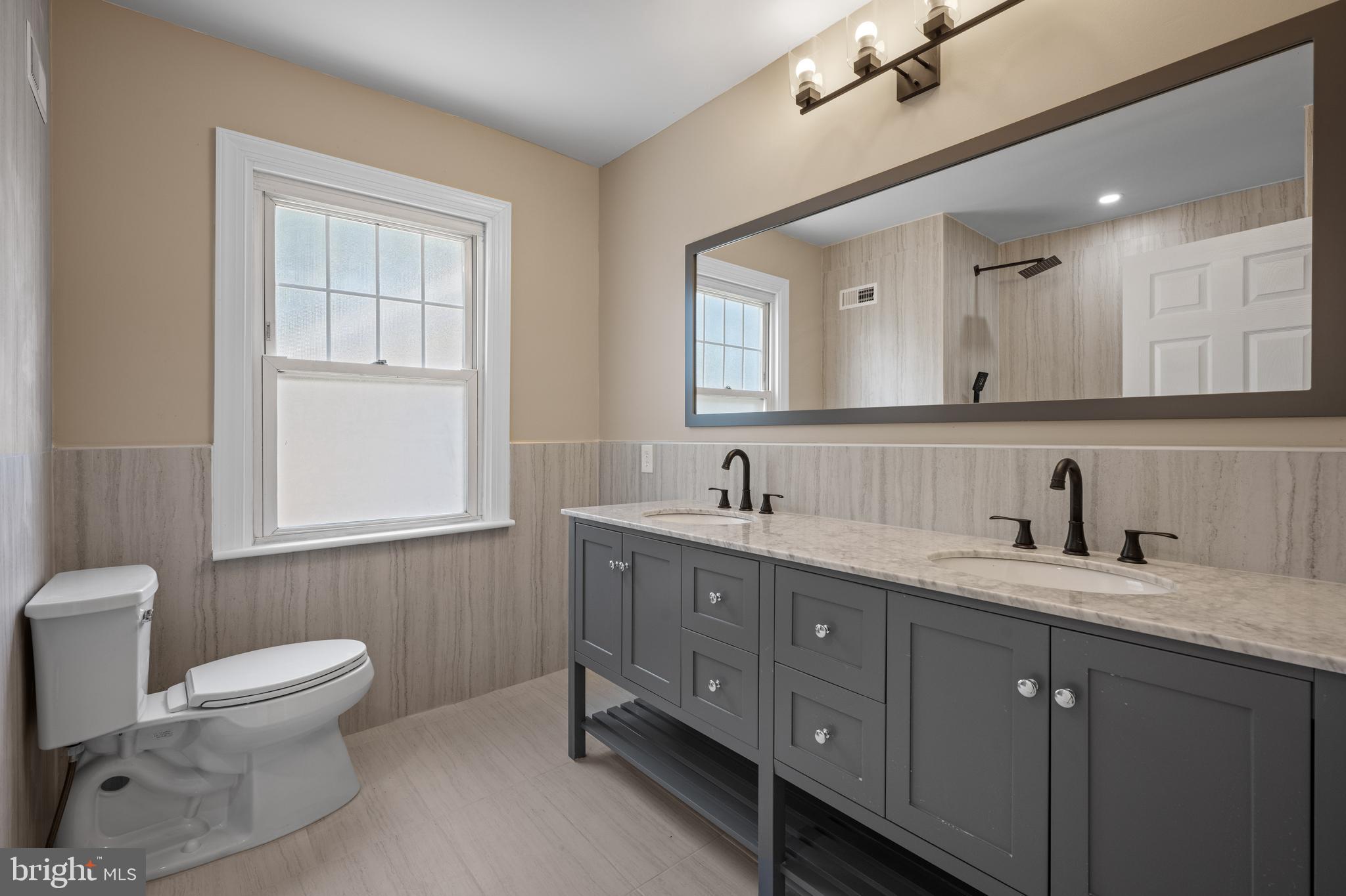 15 Lafayette Road Audubon, NJ 08106 - Photo 41 of 50 a bathroom with a toilet sink double vanity and mirror