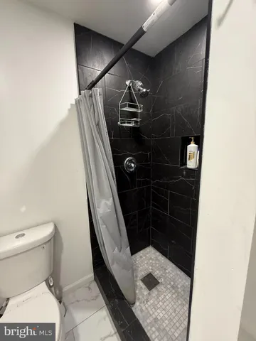 a bathroom with a toilet and a shower