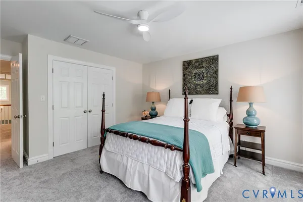 a bedroom with a bed a mirror and lamp