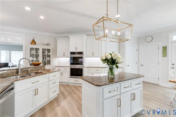 a kitchen with granite countertop white cabinets and a stove