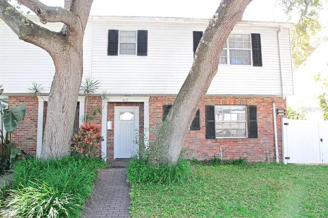 a view of a brick house with a small yard