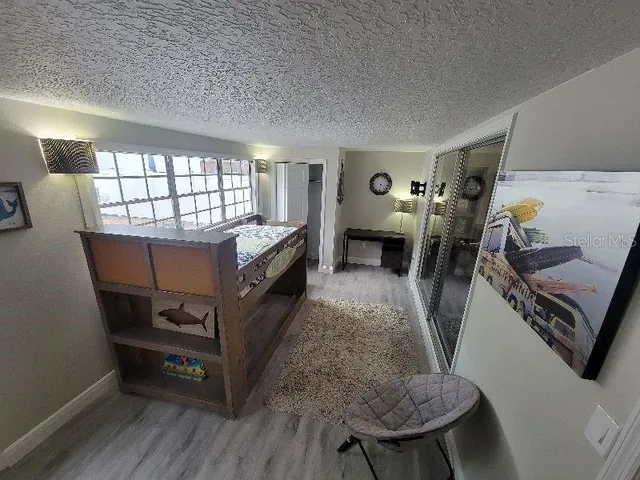 a hallway with a computer on the desk and wooden floor