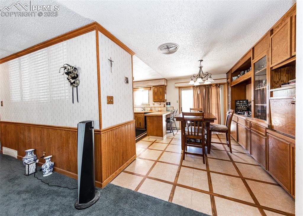 126 La Rochelle Drive Pueblo, CO 81005 - Photo 5 of 42 a kitchen with stainless steel appliances kitchen island granite countertop dining table chairs and a refrigerator