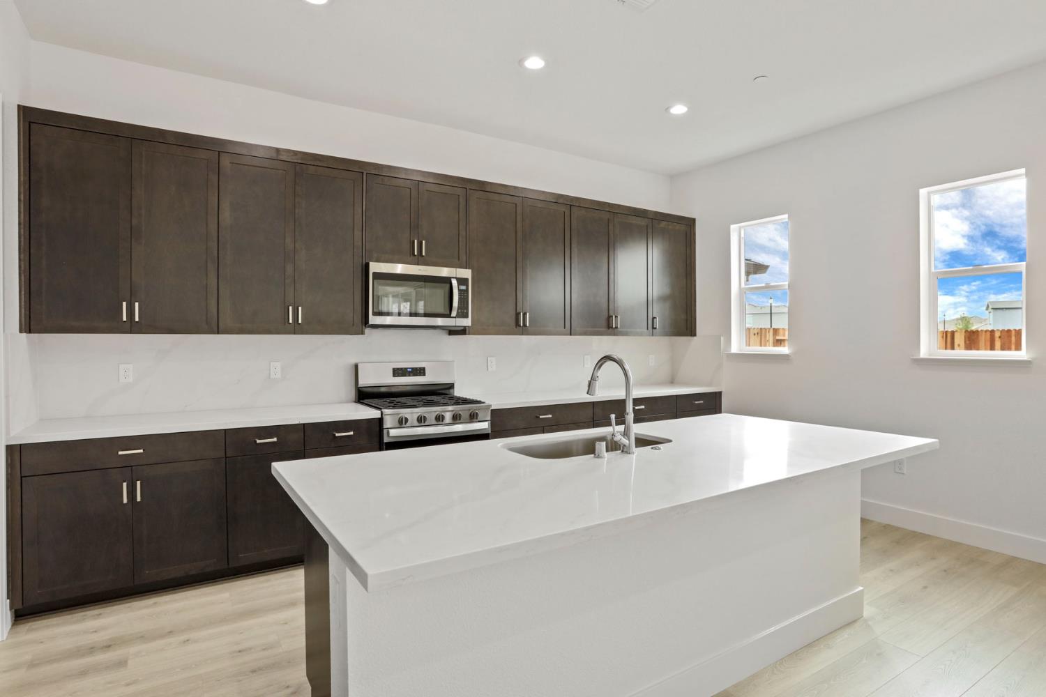 2291 Paramount Lane Manteca, CA 95337 - Photo 11 of 32 a kitchen with stainless steel appliances granite countertop a sink a stove a microwave a counter space and cabinets