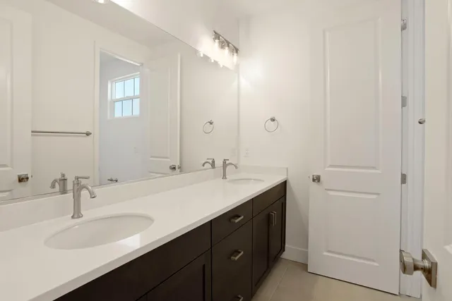a bathroom with a double vanity sink and a mirror