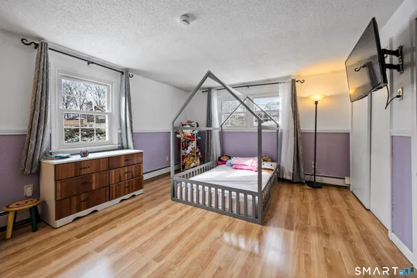 a bedroom with a bed and wooden floor