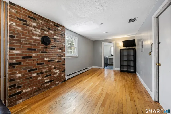 a view of empty room with a fireplace and wooden floor